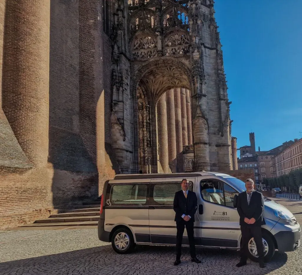 Véhicule corbillard et conseillers funéraires devant la cathédrale d'Albi.